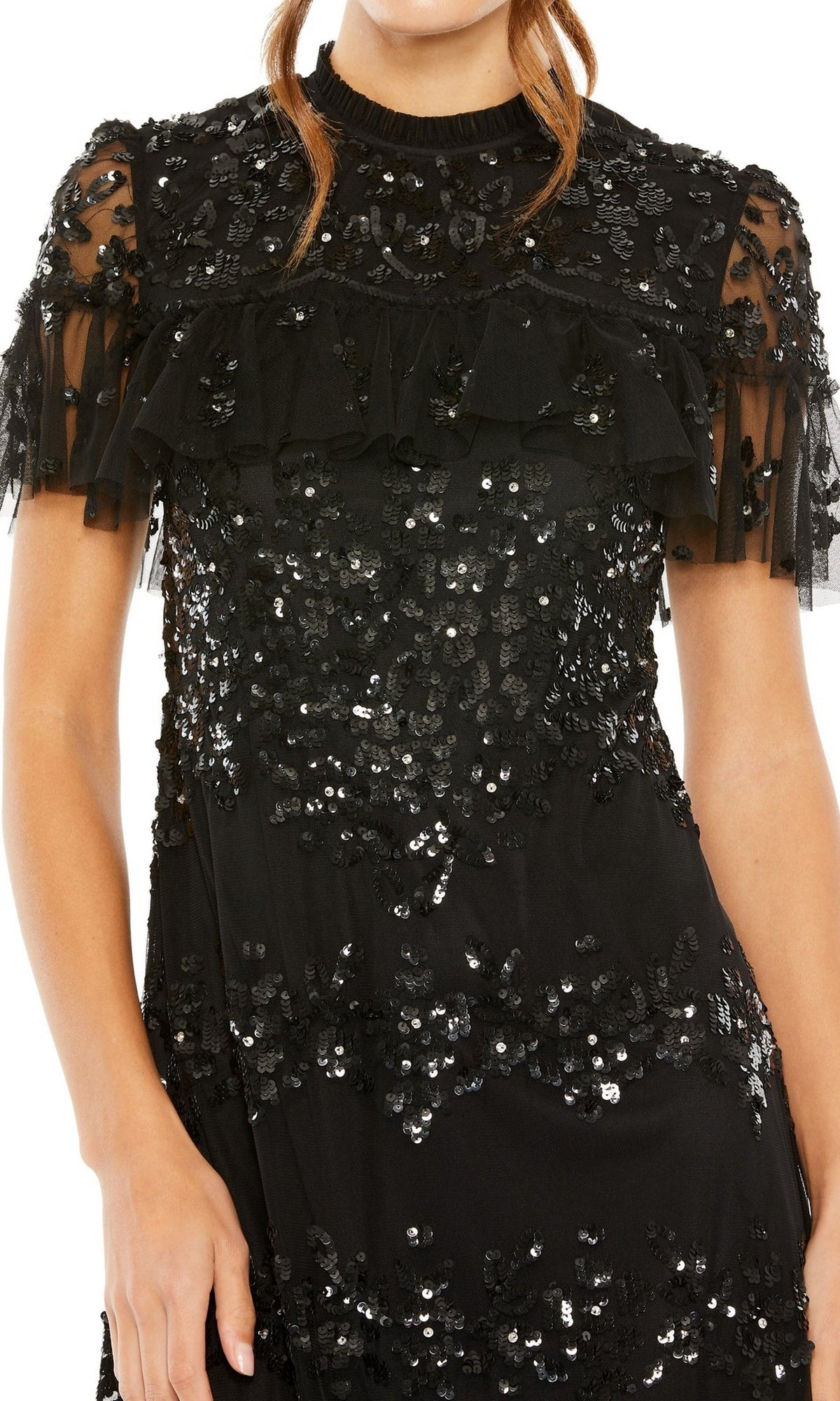 A person in the Mac Duggal 9193 Black Midi Wedding Guest Dress—knee-length, short sheer sleeves, and covered in black sequins—stands against a white background.